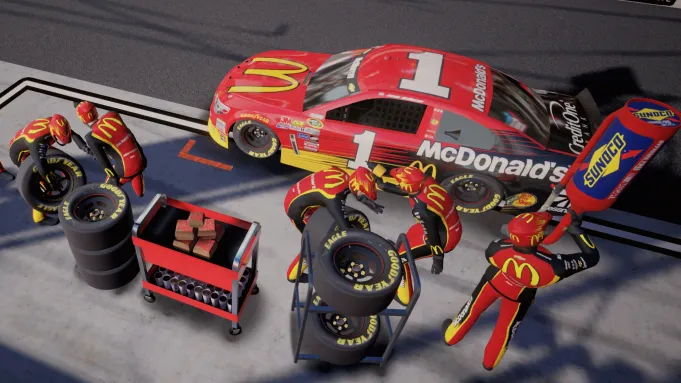 Action shot of McDonald's NASCAR pit crew changing tires and refilling gas