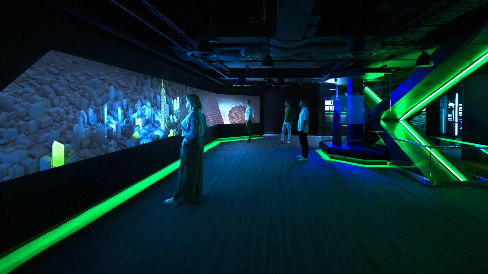 People looking at the Vista Screen, playing a video with features of Chicago. The 875 N Michigan physical model is shown on the right.