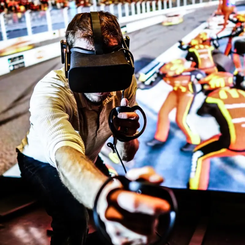 Man in VR goggles mimics a tire replacement motion against a McDonald's backdrop