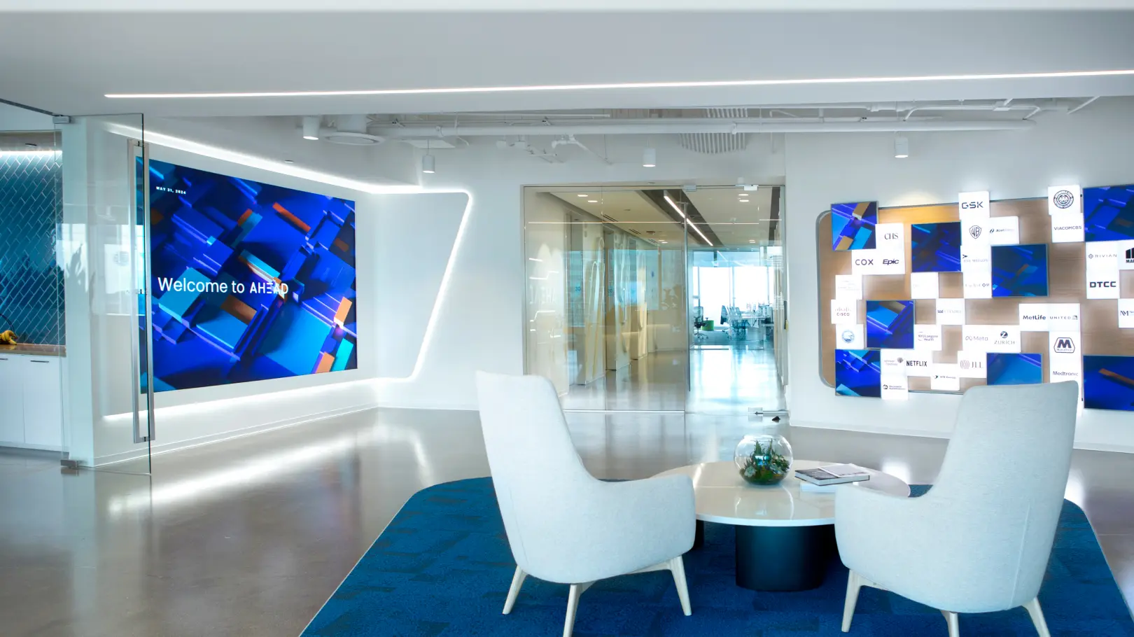 AHEAD corporate lobby featuring two elegant white chairs, and the AHEAD Welcome Wall and Logo Wall