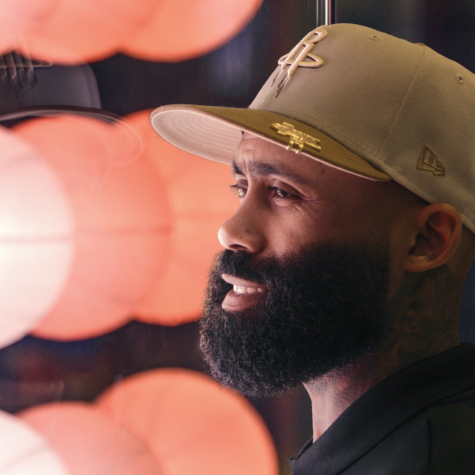 Portrait of a man looking at a series of illuminated 3D printed basketballs